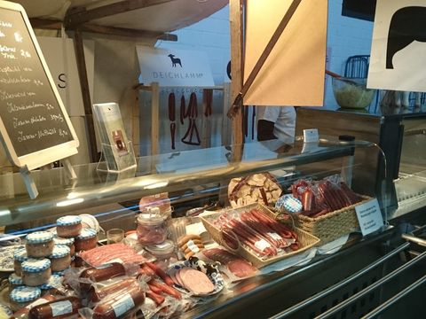 Marktstand mit Wurstwaren und Kreidetafel in der Markthalle Neun in Berlin-Kreuzberg