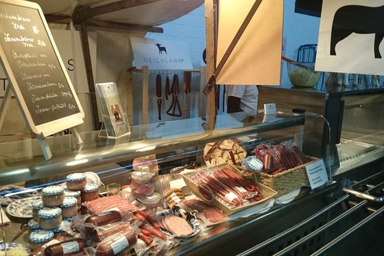 Marktstand mit Wurstwaren und Kreidetafel in der Markthalle Neun in Berlin-Kreuzberg